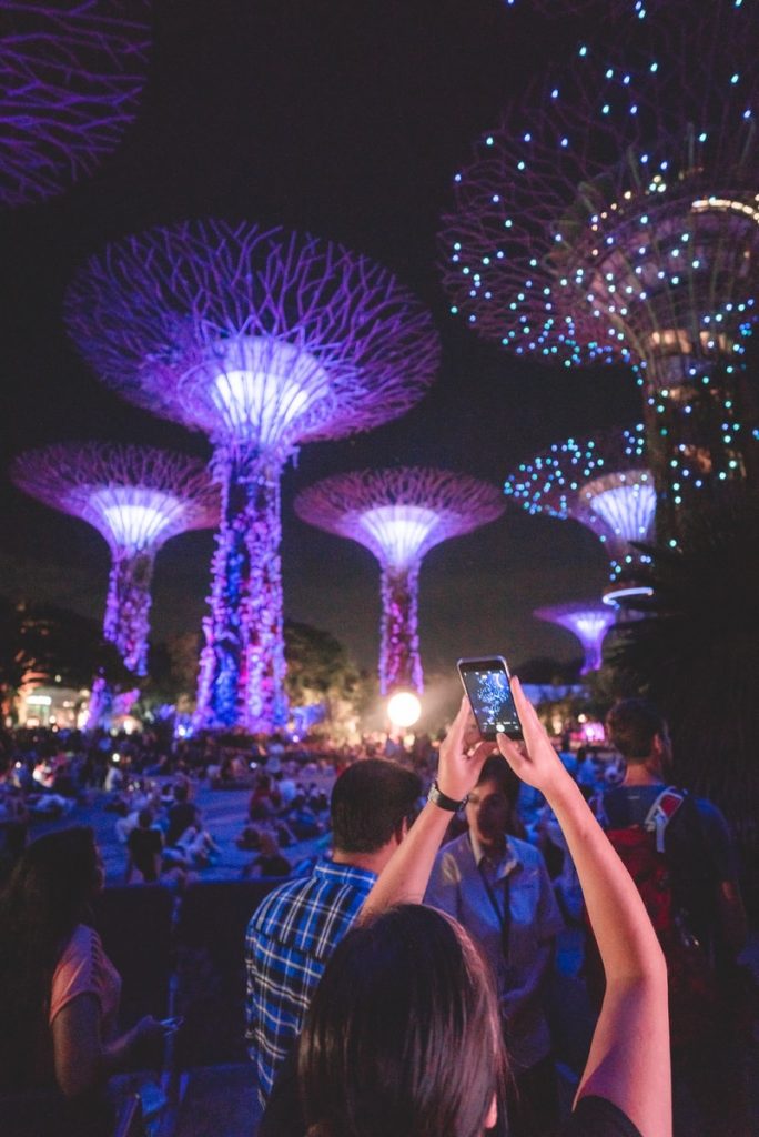 light show singapore woman holding smartphone up while taking picture